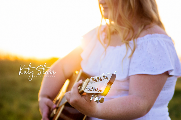 alt="high school senior girl playing guitar for senior pictures"